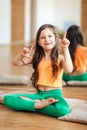 A cute little girl in a yoga room, a smile without teeth, full growth Royalty Free Stock Photo