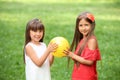 Cute little girls with ball in park on summer day