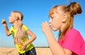 Cute little girls blowing soap bubbles on sunny day Royalty Free Stock Photo