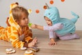 Cute little girls in giraffe and narwhal costume play at home. Halloween party