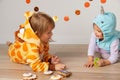 Cute little girls in giraffe and narwhal costume play at home. Halloween party