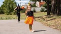 cute little girls in a Halloween costume of a witch with a pumpkin basket for sweets in her hands outdoors. lantern jack, happy Royalty Free Stock Photo