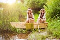 Cute little girls having fun in a boat by a river