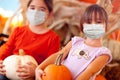 Cute Little Girls Holding Their Pumpkins At A Pumpkin Patch Wearing Medical Face Masks