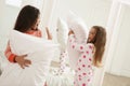 Cute little girls in pajamas having pillow fight at home. Happy childhood Royalty Free Stock Photo