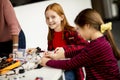 Cute little girls programming electric toys and robots at robotics classroom