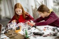 Cute little girls programming electric toys and robots at robotics classroom