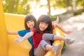 Cute little girls siblings having fun on playground outdoors on sunny summer day. Children on plastic slide. Fun activity for kid Royalty Free Stock Photo