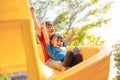 Cute little girls siblings having fun on playground outdoors on sunny summer day. Children on plastic slide. Fun activity for kid Royalty Free Stock Photo