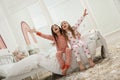 Cute little girls sitting on bed in room after pillow fight. Happy childhood