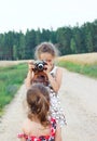 Cute little girls taking pictures with old film camera outdoor.  Pretty children in nature Royalty Free Stock Photo