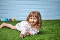 Cute little happy girl, lying on a green Mat made of artificial grass Royalty Free Stock Photo
