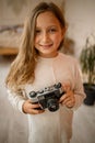 Cute Little Happy Girl With Vintage Photo Camera in a bright room Royalty Free Stock Photo
