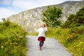 Cute little happy toddler girl running on nature path in Glenveagh national park in Ireland. Smiling and laughing baby Royalty Free Stock Photo