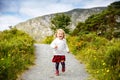 Cute little happy toddler girl running on nature path in Glenveagh national park in Ireland. Smiling and laughing baby Royalty Free Stock Photo