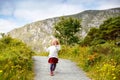 Cute little happy toddler girl running on nature path in Glenveagh national park in Ireland. Smiling and laughing baby Royalty Free Stock Photo