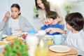 Cute little hispanic boy having breakfast together with his mom and siblings. Latin family enjoying meal together Royalty Free Stock Photo