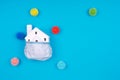 Cute little house covered with medicine mask and plastic balls as viruses on the blue with place for text. Epidemic