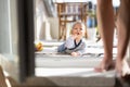 Cute little infant baby boy playing with toys outdoors at the patio in summer being supervised by her mother seen in the