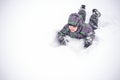 Cute little kid boy in colorful winter clothes laying down on . Royalty Free Stock Photo