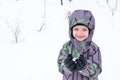 Cute little kid boy in colorful winter clothes making snow angel Royalty Free Stock Photo