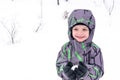 Cute little kid boy in colorful winter clothes making snow angel Royalty Free Stock Photo