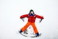 Cute little kid boy in colorful winter clothes making snow angel, laying down on snow. Active outdoors leisure with Royalty Free Stock Photo