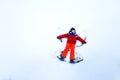 Cute little kid boy in colorful winter clothes making snow angel, laying down on snow Royalty Free Stock Photo