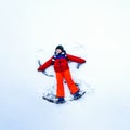 Cute little kid boy in colorful winter clothes making snow angel, laying down on snow. Active outdoors leisure with Royalty Free Stock Photo