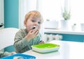 Cute little kid boy hungry eating healthy food in kitchen at home Royalty Free Stock Photo