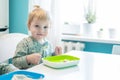 Cute little kid boy hungry eating healthy food in kitchen at home, holding spoon Royalty Free Stock Photo