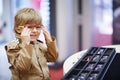 Cute little kid boy at optician store during choosing his new glasses Royalty Free Stock Photo