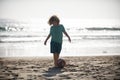 Cute little kid boy playing football with foot ball on sandy beach. Royalty Free Stock Photo