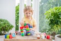 Cute little kid boy with playing with lots of colorful plastic blocks indoor. Active child having fun with building and Royalty Free Stock Photo