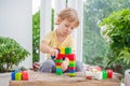 Cute little kid boy with playing with lots of colorful plastic blocks indoor. Active child having fun with building and Royalty Free Stock Photo