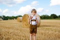 Cute little kid boy in traditional Bavarian costume in wheat field Royalty Free Stock Photo