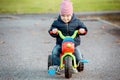 Cute little kid boy in warm autumn clothes having fun with tricycle Royalty Free Stock Photo