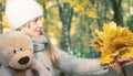 Cute little kid daughter congratulating mum with mothers day, smiling girl with Teddy Bear presents autumn yellow leaves Royalty Free Stock Photo