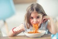 Cute little kid girl eating spaghetti bolognese at home