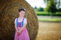 Cute little kid girl in traditional Bavarian costume in wheat field Royalty Free Stock Photo