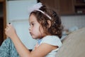 Cute little kid girl using mobile phone sitting on sofa alone Small child holding phone Royalty Free Stock Photo