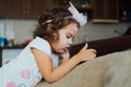 Cute little kid girl using mobile phone sitting on sofa alone Small child holding phone Royalty Free Stock Photo