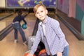 Cute little kid teen boy with ball at bowling club with friends Royalty Free Stock Photo