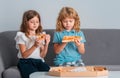 Cute little kids boy and girl eating Pizza at home. Children holding a slices of pizza on party at home. Two young Royalty Free Stock Photo