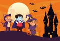 Cute little kids dressed as a cat and witch with dracula in castle scene Royalty Free Stock Photo