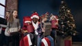 Cute little kids joying the gifts getting from Santa Claus on the christmas tree background.