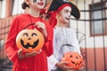 Cute little kids with pumpkin candy buckets wearing Halloween costumes going trick-or-treating outdoors, closeup Royalty Free Stock Photo
