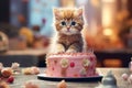 A cute little kitten near the cake. Birthday celebration