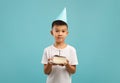 Cute Little Korean Boy Wearing Party Hat Holding Piece Of Birthday Cake Royalty Free Stock Photo
