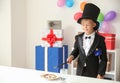 Cute little magician showing trick indoors Royalty Free Stock Photo